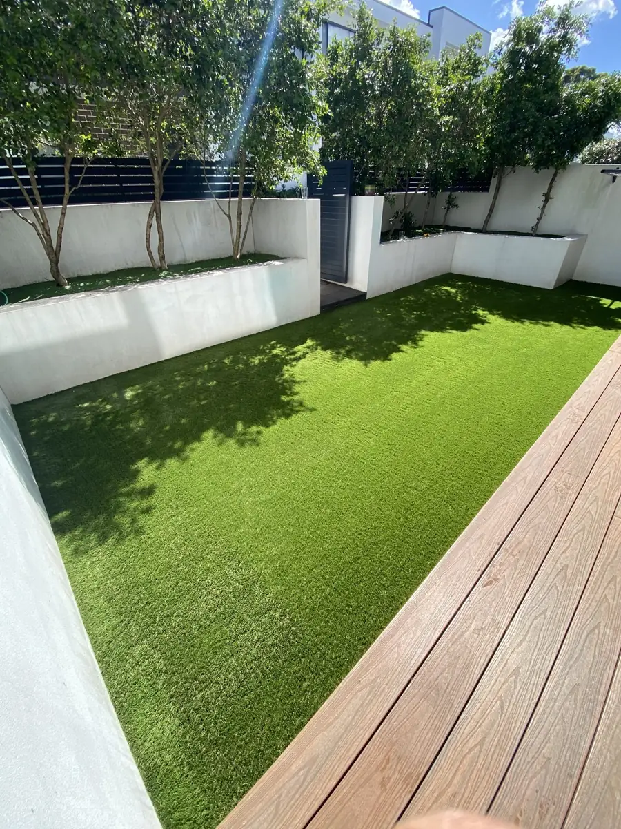 Artificial lawn alongside a composite deck and rendered planters