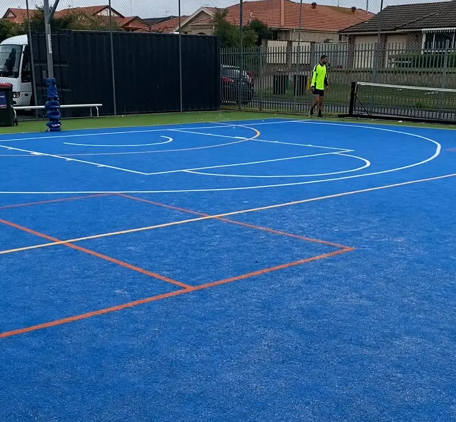 Blue synthetic multi-sport court with basketball and court line markings