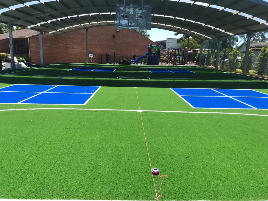 Covered multi-sport court surfaced with synthetic grass