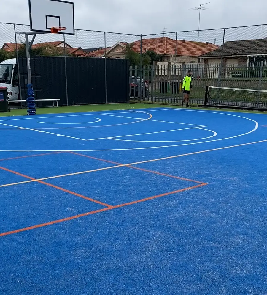 Blue synthetic multi-sport court with basketball and court line markings, installed by Turfland