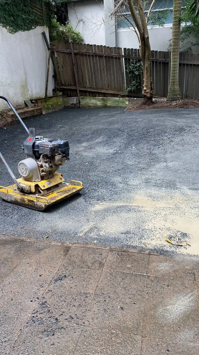 Compacting the base before laying synthetic grass
